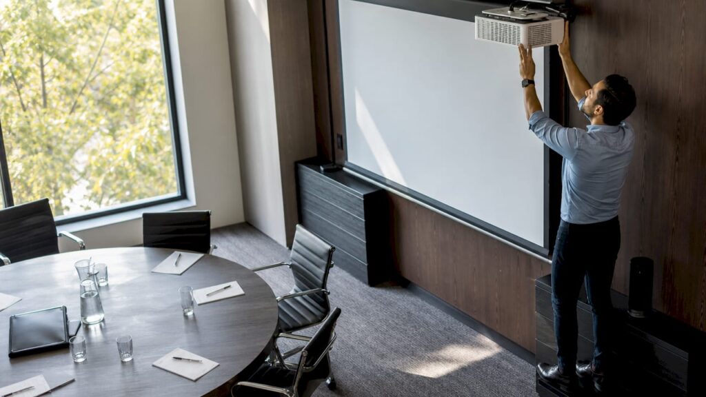Trainer setting up projector in corporate training room